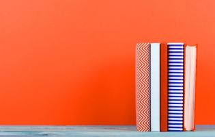 Image of 5 books displayed in front of a bright orange wall